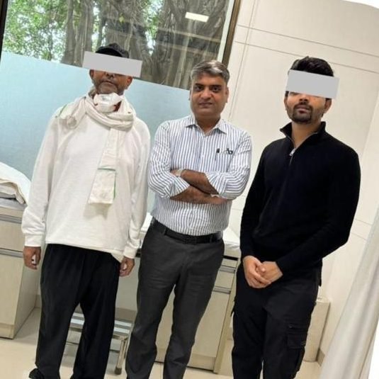 Liver transplant patient and living donor standing with Dr Manoj Gupta one month after surgery